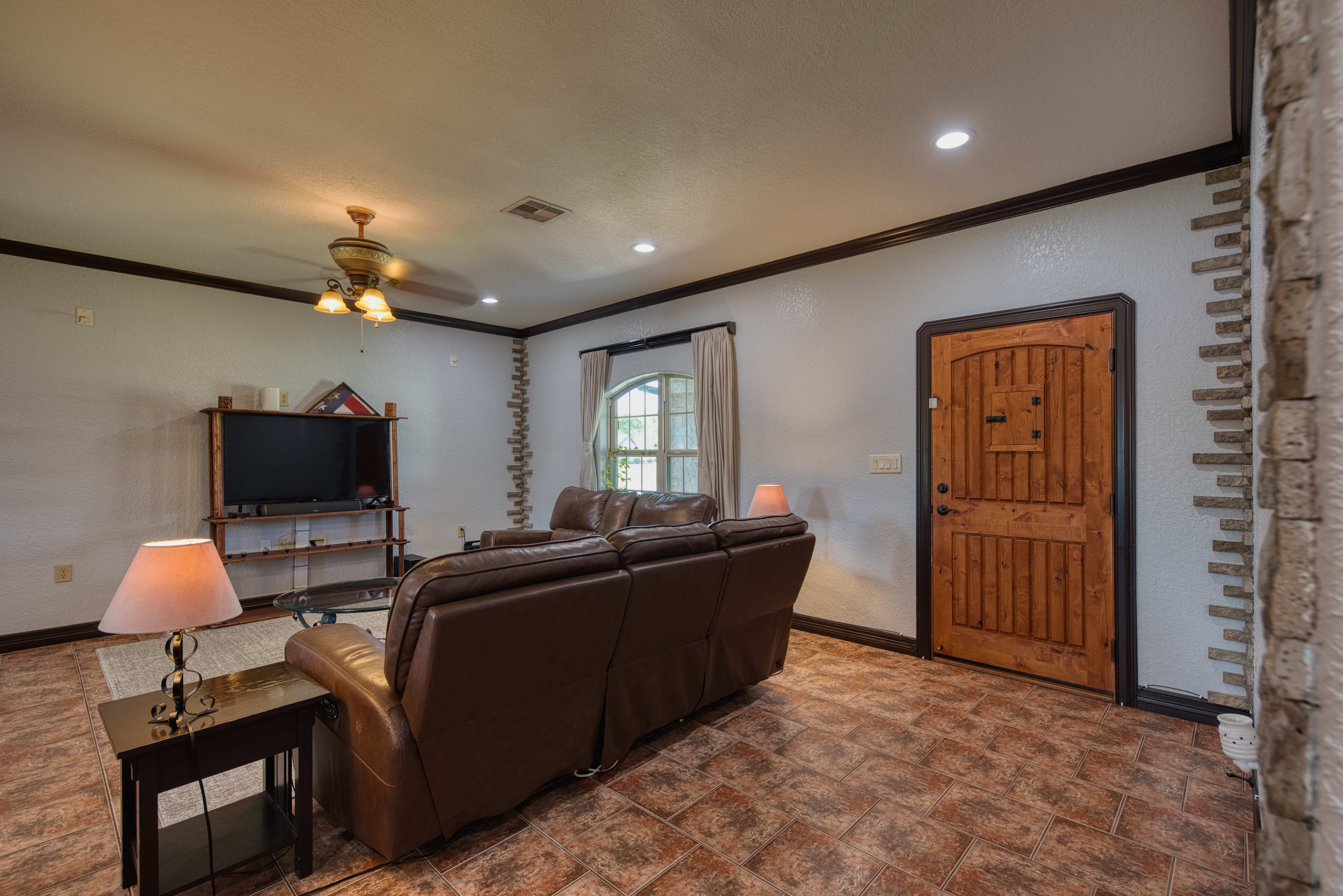Living room with leather sofa and rustic wood front door