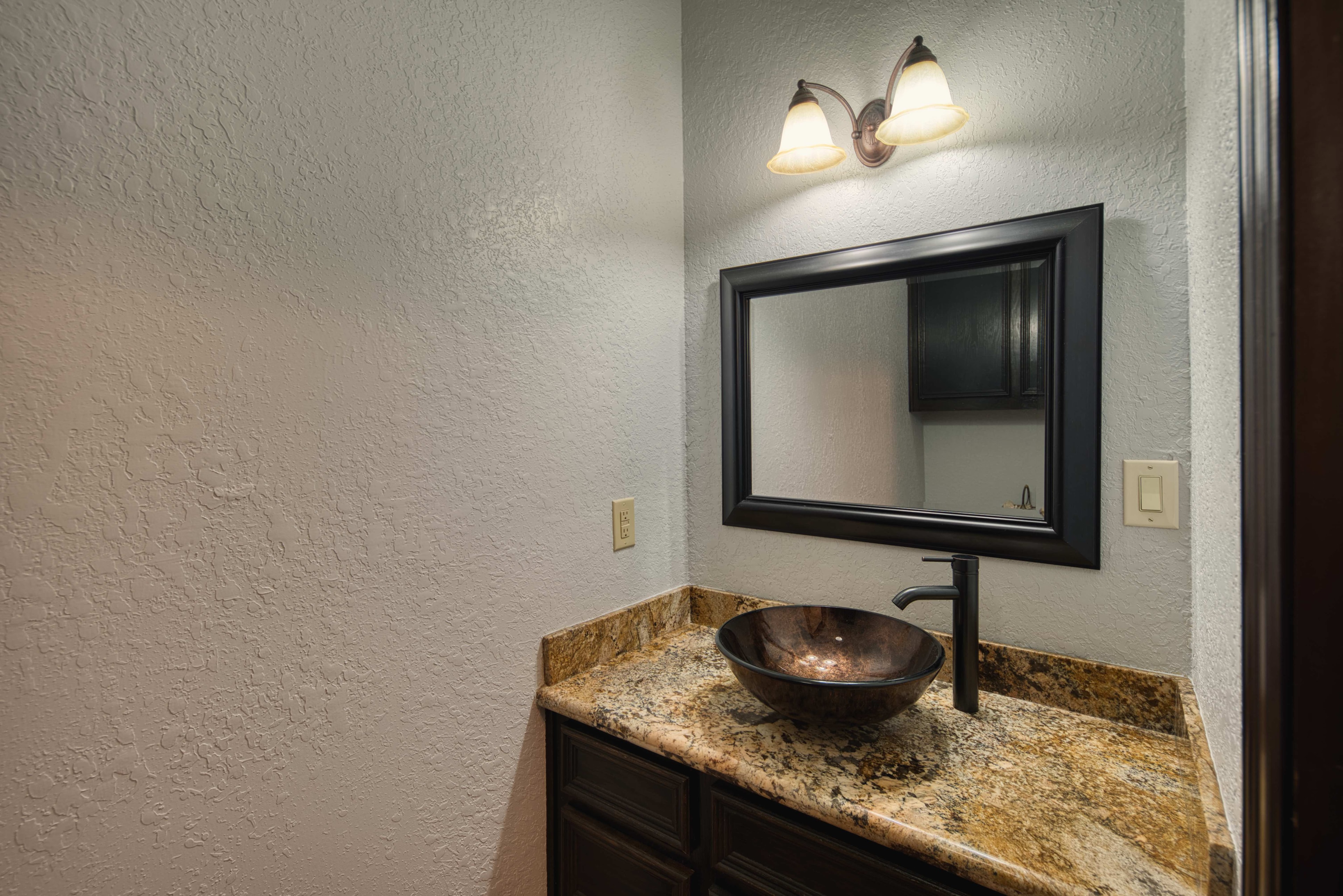 Half bathroom with vessel sink and granite countertop