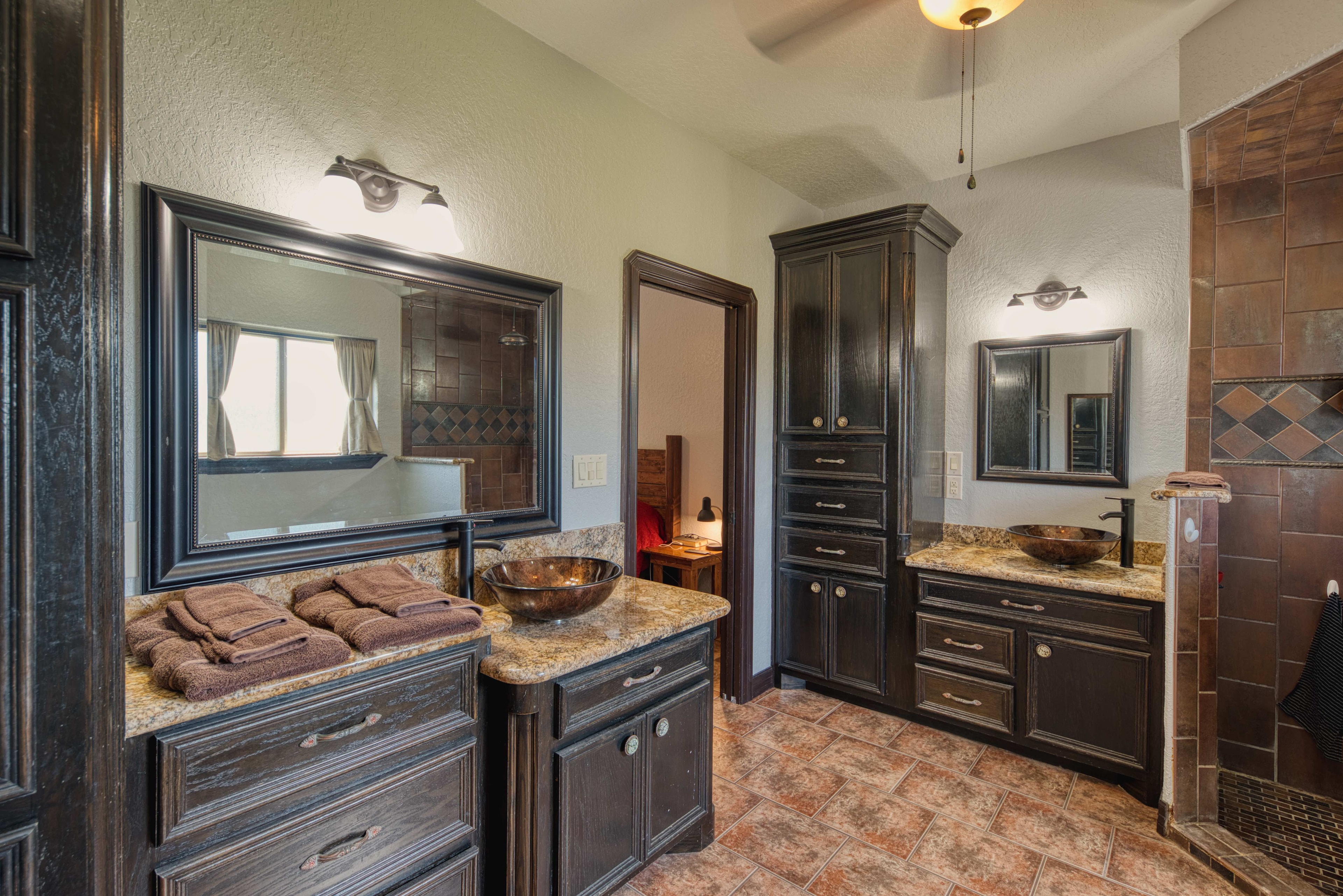 Master bathroom with dark cabinetry, granite countertops and bronze fixtures