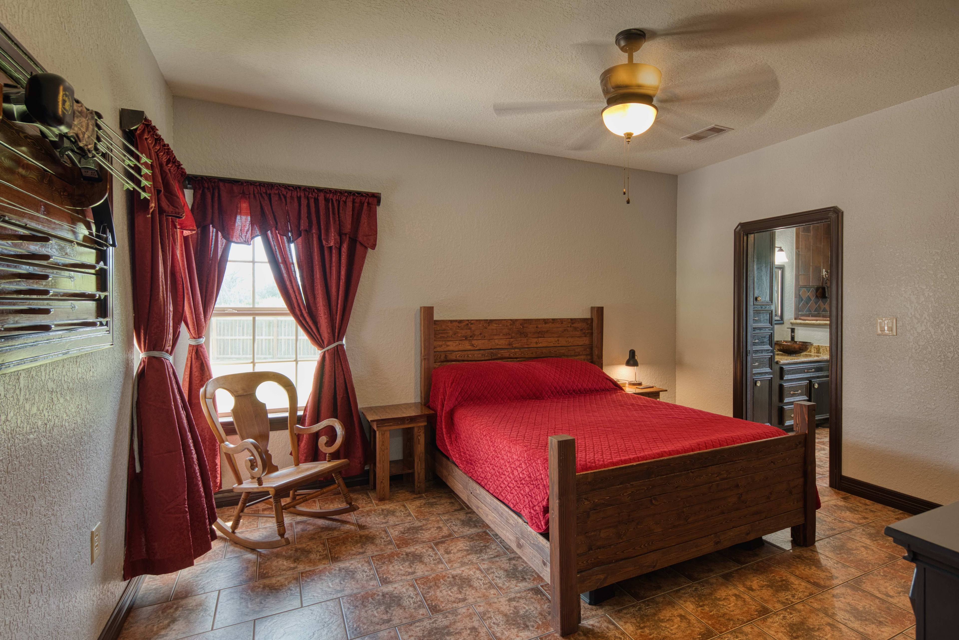 Master bedroom with rustic wood furniture and red bedding
