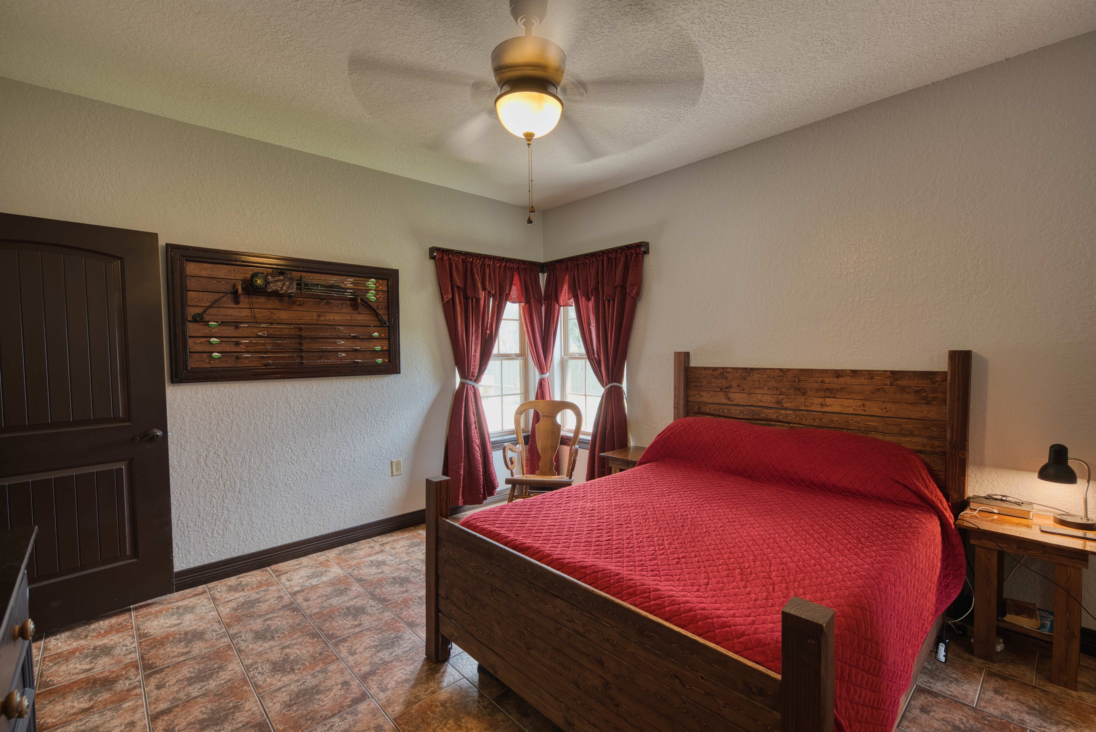 Master bedroom alternate angle with bow display and red curtains